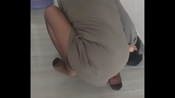 Mature woman wearing turban and nylon socks is mopping the floor