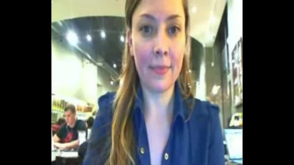 Un modèle de caméra se déshabille et clignote dans un café très bondé devant une webcam